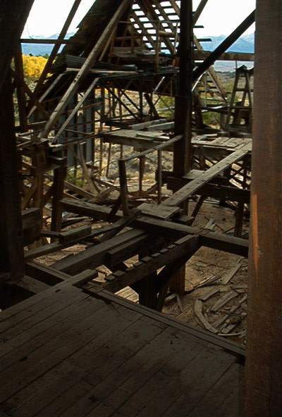 1986 Ford Bronco - The interior of a decaying wooden building shows extensive damage and disrepair.