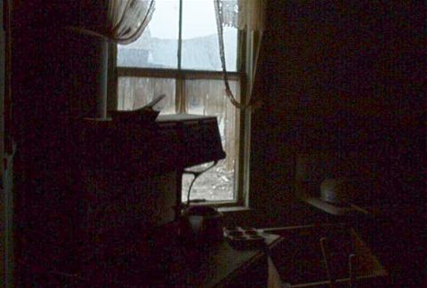 1986 Ford Bronco - The image depicts the interior of a dimly lit room, with a window offering a view of the outside.