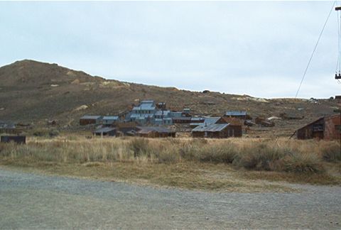 1986 Ford Bronco - A view of an old, possibly abandoned town with weathered structures on a barren hillside.