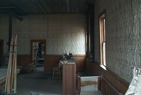 1986 Ford Bronco - Interior of an old building with patterned walls, a wooden counter, and a stool.