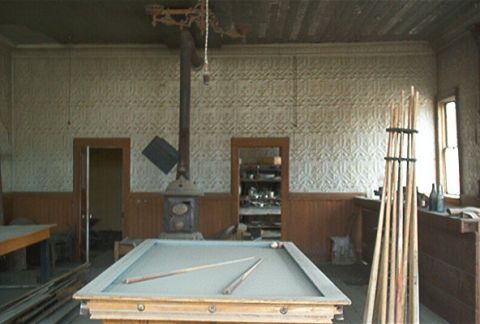 1986 Ford Bronco - The interior of a room appears to be an old saloon or game room, complete with a pool table and a wood-burning stove.