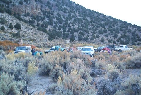 1986 Ford Bronco - A group of vehicles and tents are set up in a remote, arid landscape, likely for an off-road event.