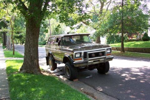 1979 Ford Bronco - This 1978 Ford Bronco is parked on a residential street with trees and grass in the background.