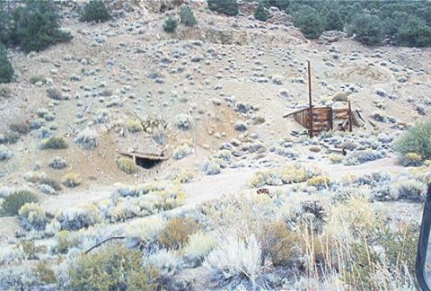 1986 Ford Bronco - A desolate scene of abandoned mine shafts and weathered wooden structures in a dry, scrub-covered landscape.