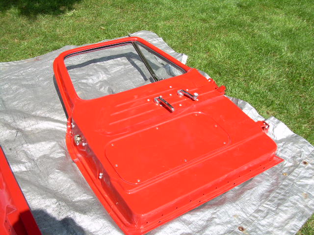Red-painted truck door with window frame on tarp