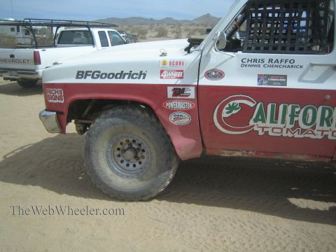 1990 Ford Bronco - red and white front fender of a sponsored off-road race truck shows BFGoodrich and California Tomato decals with names Chris Raffo and Denn…
