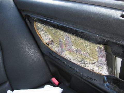 1974 Ford F-100 - Close-up view of a damaged interior door panel, revealing torn fabric and exposed material beneath the trim.