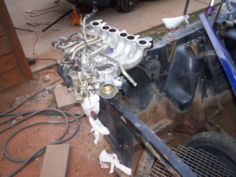 2005 Ford Mustang - Engine intake manifold and throttle body assembly with hoses and wiring. Part of a larger vehicle disassembly project.