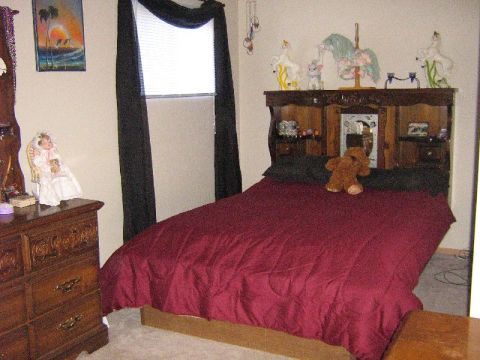 1995 Ford Bronco - This bedroom scene includes a bed, dresser, and window with black curtains.