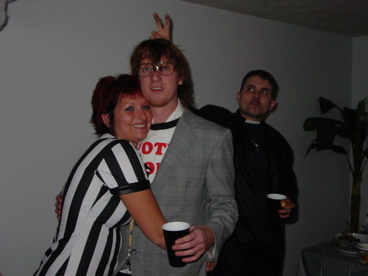 Three people in costumes, one in a referee shirt, one in a suit and glasses, and one dressed as a priest, holding cups