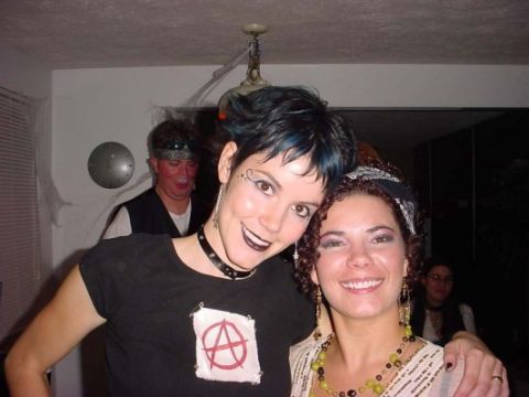 1995 Ford Probe - Two women pose for a photo during a Halloween party, with a man and other guests in the background.