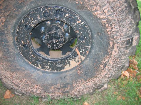 1992 Ford Mustang - Close-up of a heavily mud-splattered tire and wheel assembly.