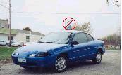 2000 Ford Escort - A blue 2000 Ford Escort coupe is parked outside on a cloudy day.
