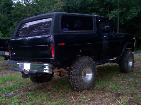 1995 Ford Bronco - This black SUV features a lifted suspension, large off-road tires, and a chrome rear bumper.