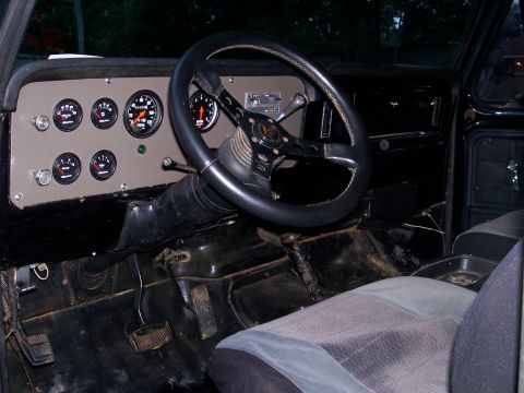 1995 Ford Bronco - The dashboard features several aftermarket gauges and a custom steering wheel, indicating modifications to the vehicle's interior.