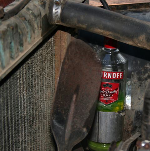 1979 Jeep CJ5 - A bottle of Smirnoff vodka is stored in the engine bay next to the radiator.