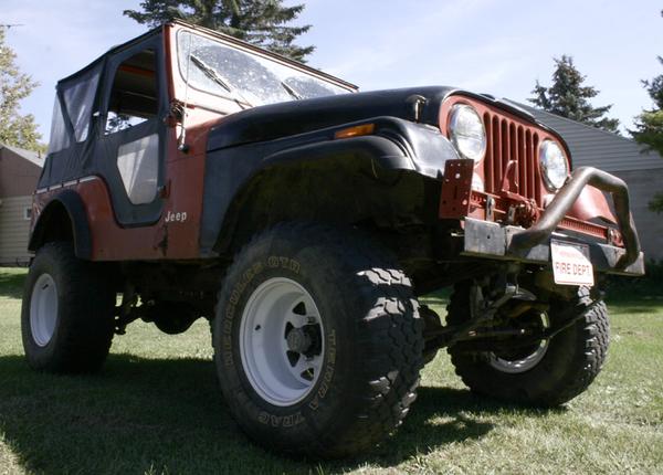 Red and black Jeep CJ5 with soft top and "FIRE DEPT" plate