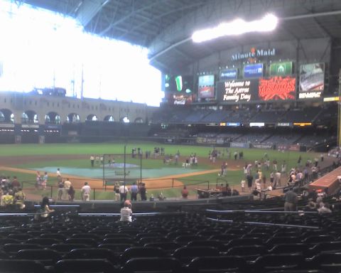 2000 Ford Crown Victoria - A wide view of a baseball stadium shows the field, seating areas, and large electronic scoreboards.
