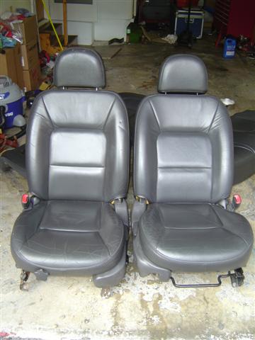 1994 Ford Taurus - Two black leather car seats are displayed in front of a garage.