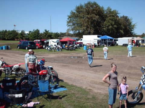 1995 Ford Probe - A sunny day at an outdoor event features motorcycles, people, and various vehicles parked in a dirt lot.