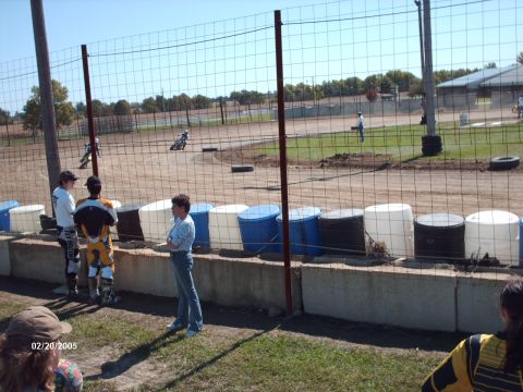 1995 Ford Probe - Motorcycles race on a dirt track as spectators observe from the sidelines.
