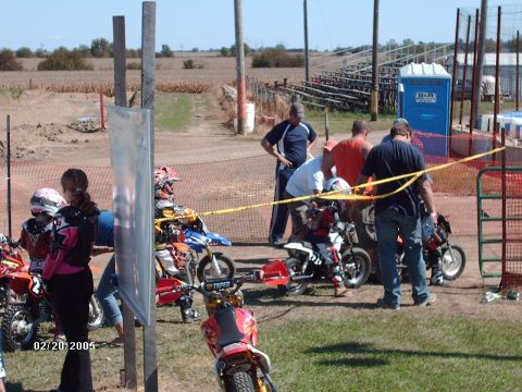 1995 Ford Probe - People and dirt bikes are at a track event with bleachers visible in the background.