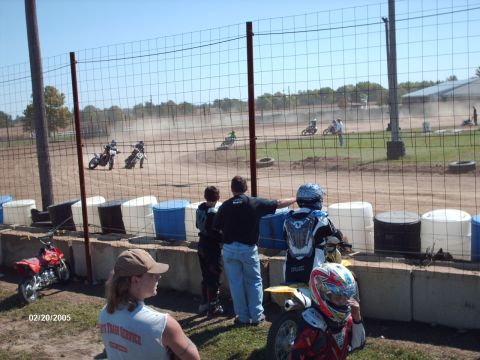 1995 Ford Probe - Spectators watch a motorcycle race on a sunny day at the track.