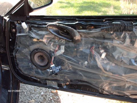 1995 Ford Probe - Interior view of a car door with the speaker removed, revealing wiring and a carbon fiber-style door handle.