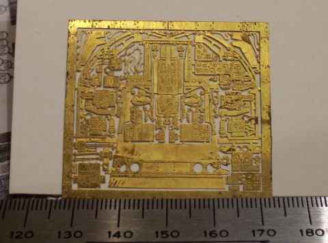1998 Ford Crown Victoria - A close-up of a brass photoetch detail sheet, likely for a model kit, showing complex panel lines and components.