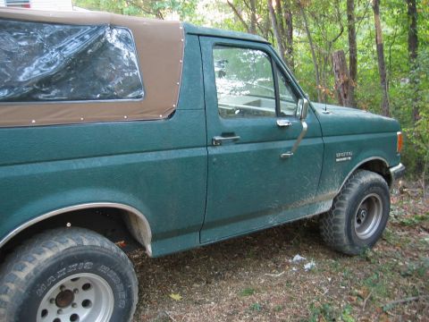 1990 Ford Bronco - This 1990 Ford Bronco features a removable brown soft top and a textured green exterior.