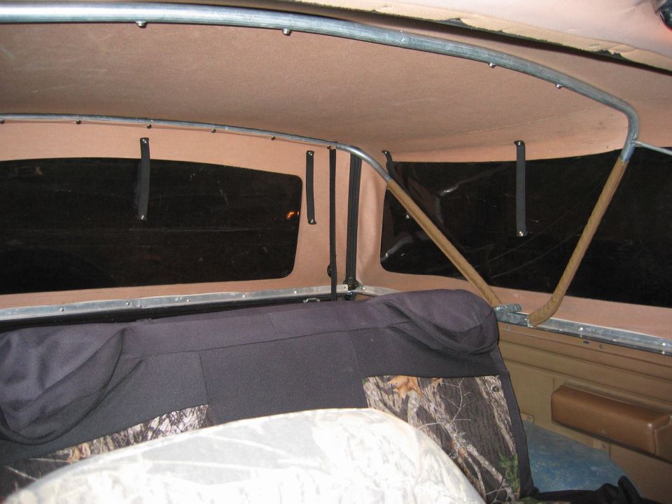 Interior view of a vehicle showing camouflage seat covers and the headliner