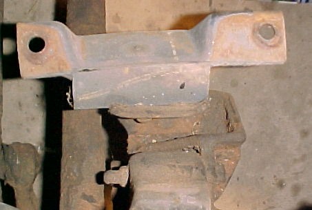 1965 Ford Mustang - Close-up of a rusted metal bracket attached to an engine block.