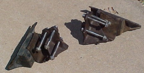 1965 Ford Mustang - Two engine mounts with bolts are shown on a concrete surface.