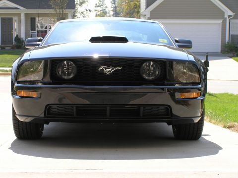 2007 Ford Mustang - A black Ford Mustang is parked in a driveway, facing the camera directly.