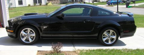 2007 Ford Mustang - Side view of a black 2007 Ford Mustang GT coupe parked in a driveway.