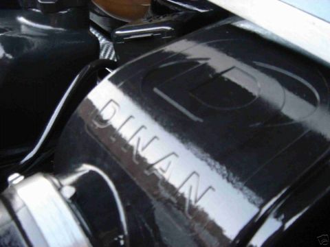 2003 MINI Cooper - Close-up of a black engine part showing the "DINAN" brand name embossed on its surface.