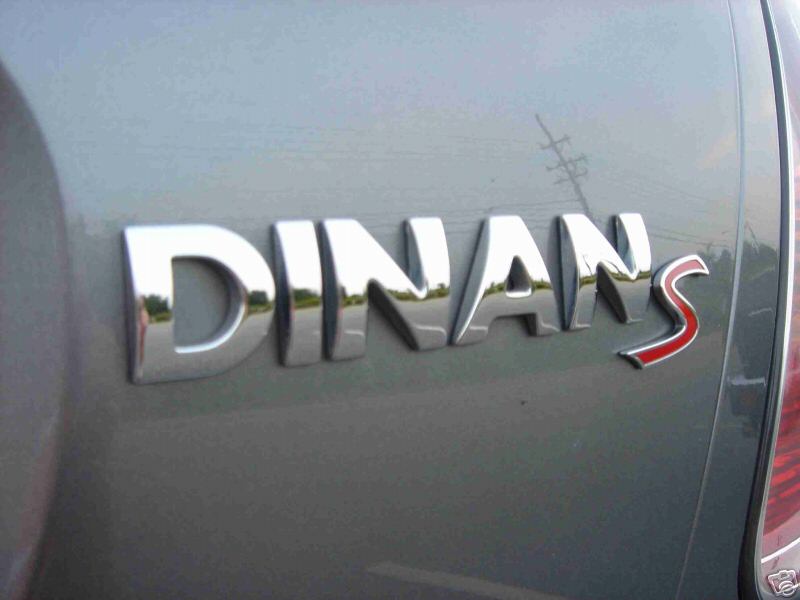 Chrome DINAN S emblem with red S on silver-gray car body panel