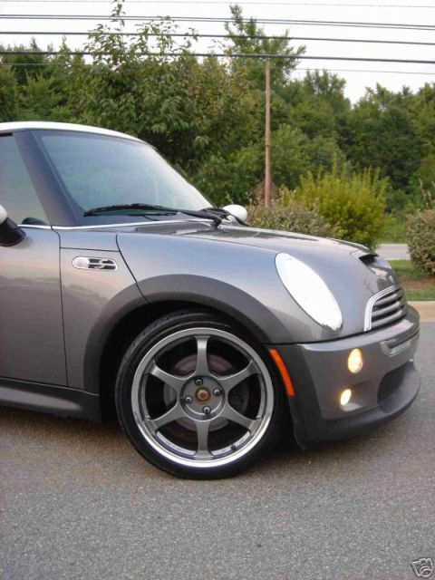2003 MINI Cooper - A gray 2003 MINI Cooper is parked on asphalt, showing its front passenger side and custom wheels.