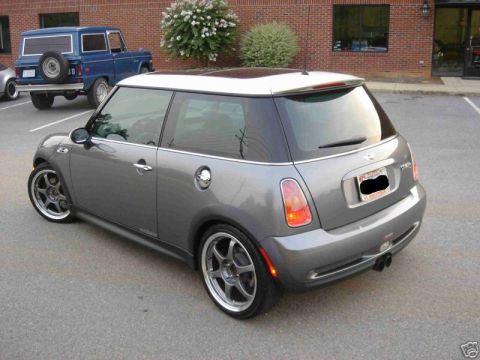 2003 MINI Cooper - A grey MINI Cooper with a white roof is parked in a lot, with a blue Ford Bronco in the background.