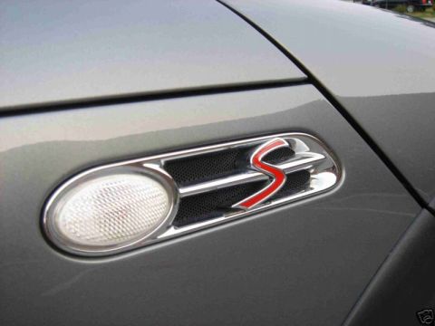 2003 MINI Cooper - Close-up of a silver MINI Cooper S side vent, showing the distinctive red S emblem and turn signal indicator.