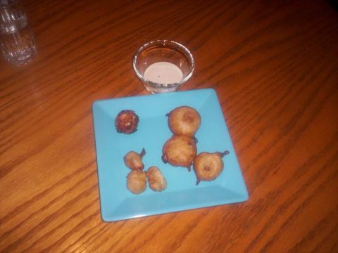 1989 Ford Bronco - A light blue plate holds several fried dough balls and a small dish of dipping sauce on a wooden surface.
