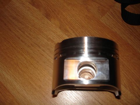 1994 Ford Probe - Close-up of an engine piston resting on a wooden floor.