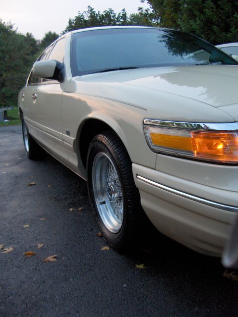 1996 Mercury Grand Marquis - Front passenger side of a 1996 Mercury Grand Marquis with chrome wheels.