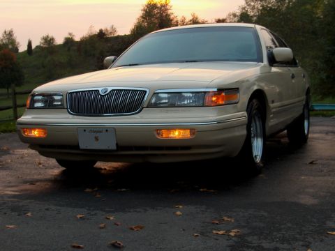 1996 Mercury Grand Marquis - A 1996 Mercury Grand Marquis is shown from the front in a three-quarter view, parked outdoors during sunset.