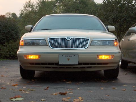 1996 Mercury Grand Marquis - Front view of a 1996 Mercury Grand Marquis, showing the grille and headlights. A second vehicle is visible to the right.