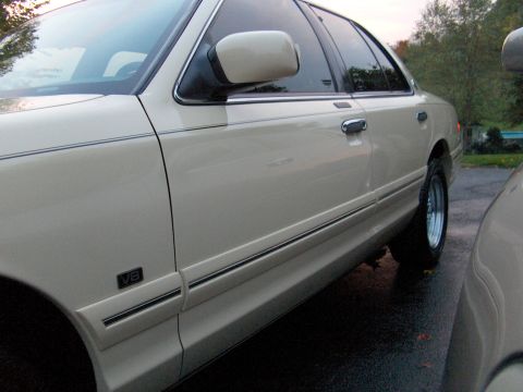 1996 Mercury Grand Marquis - Side profile of a 1996 Mercury Grand Marquis, a V8 badge and chrome accents.