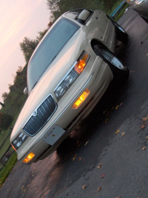 1996 Mercury Grand Marquis - Front view of a Mercury Grand Marquis parked outdoors on a wet surface with autumn leaves.