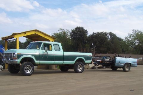 1994 Ford F-150 - A two-tone 1977 Ford F-Series truck tows a trailer carrying a disassembled truck bed.