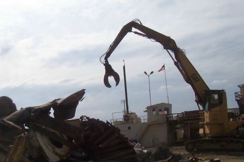 1994 Ford F-150 - A demolition crane operates over a scrap yard, with a ship visible in the distance.