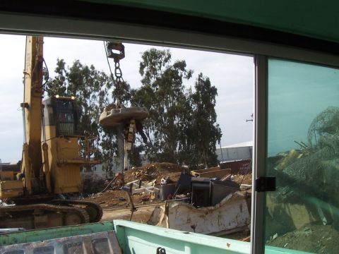 1994 Ford F-150 - A construction site is being cleared with heavy machinery, including an excavator with a magnetic grapple.